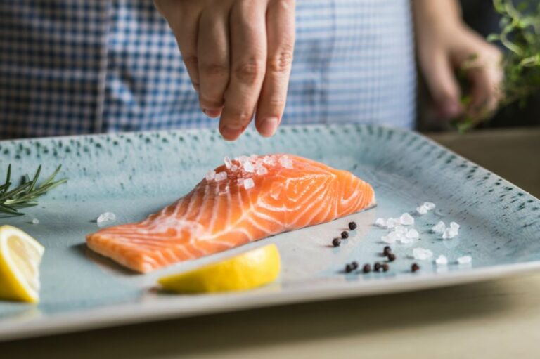 Salmon on a blue place with salt pepper and a lemon.