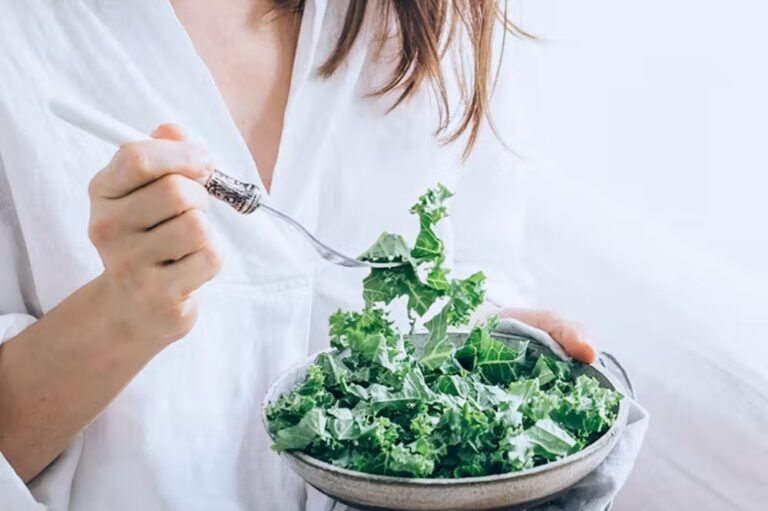 Woman Earring a kale salad.