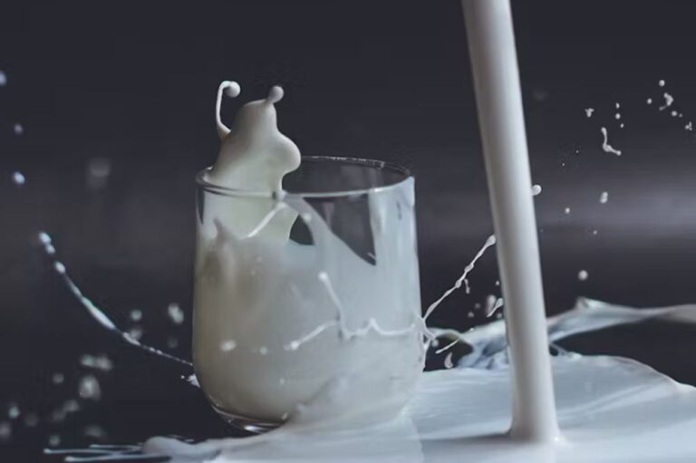 Milk being poured into a glass with a black background