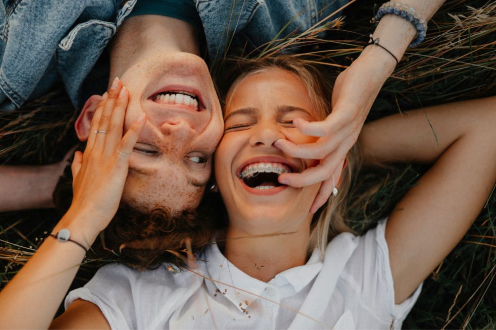 A boy and a girl laying down smiling