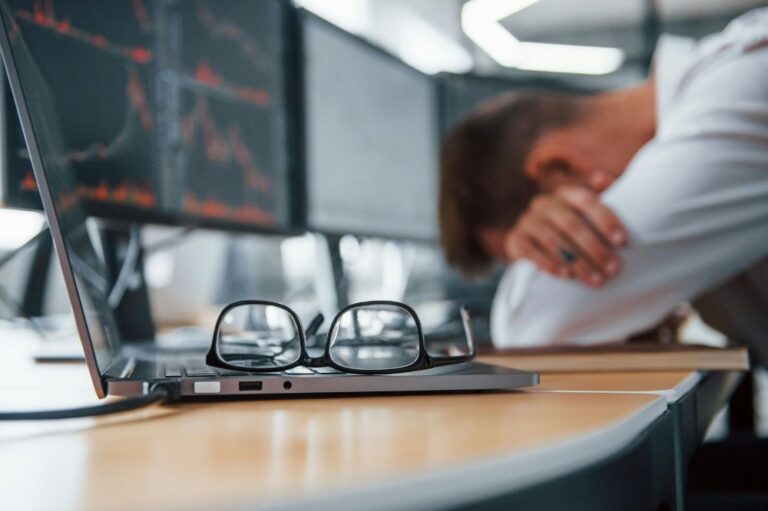 Man sleeping in glasses at computer with glasses off.