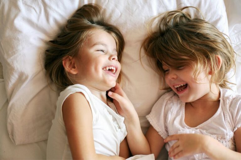 2 children playing in bed